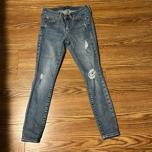 GAP Skinny jeans size 24 petite w/ rips throughout the jean in a light med wash
